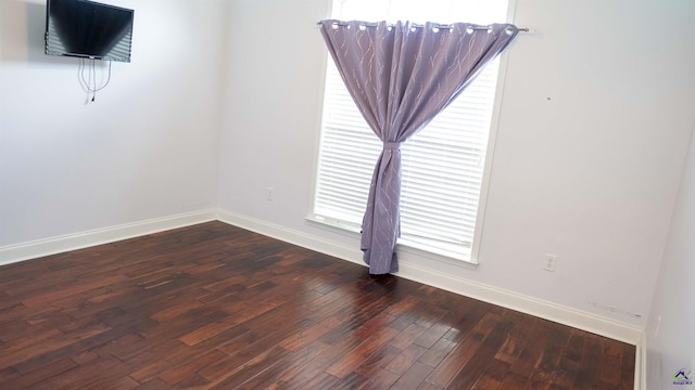 empty room featuring hardwood / wood-style flooring and baseboards