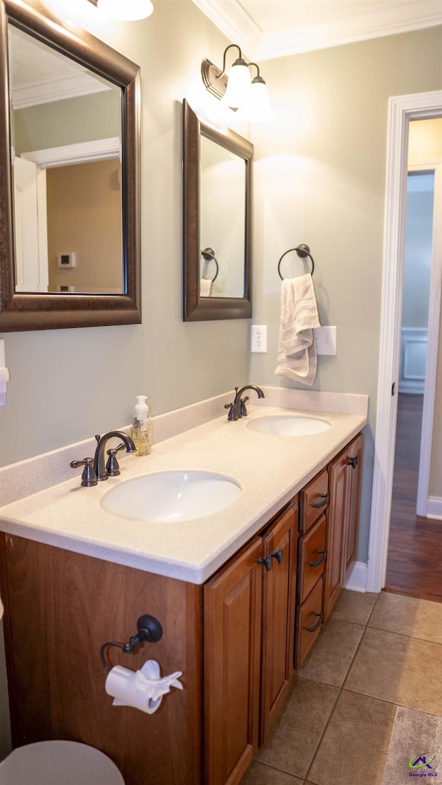 bathroom with ornamental molding, tile patterned floors, a sink, and double vanity