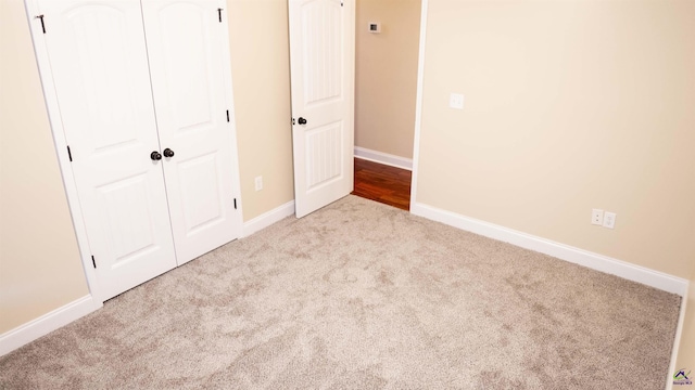 unfurnished bedroom featuring a closet, carpet, and baseboards