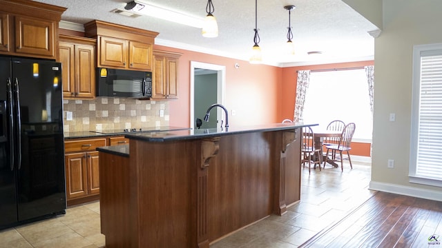 kitchen featuring decorative backsplash, dark countertops, brown cabinets, and black appliances