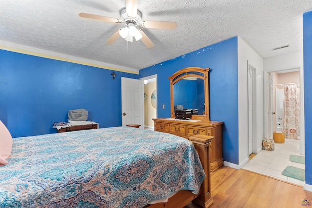 bedroom with visible vents, a ceiling fan, a textured ceiling, wood finished floors, and baseboards