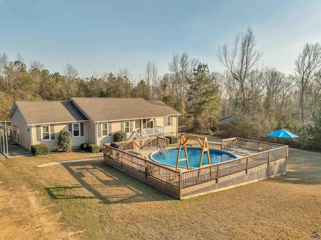 view of swimming pool featuring a deck, a yard, and a fenced in pool