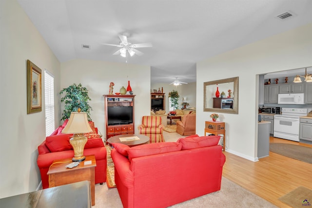 living area with baseboards, a ceiling fan, visible vents, and light wood-style floors