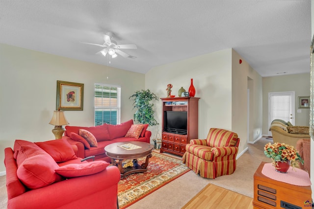 living room with a ceiling fan, a healthy amount of sunlight, a textured ceiling, and carpet floors