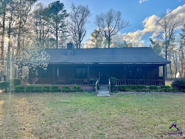 view of front of home featuring a chimney, a front lawn, a porch, and board and batten siding