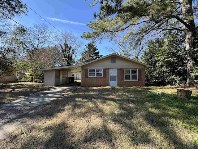 view of front of house with a carport, a front yard, concrete driveway, and brick siding