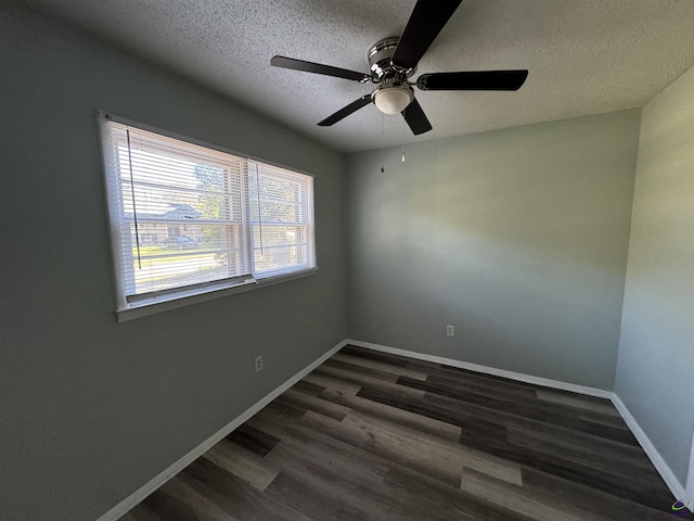 unfurnished room with a textured ceiling, baseboards, and dark wood-style flooring