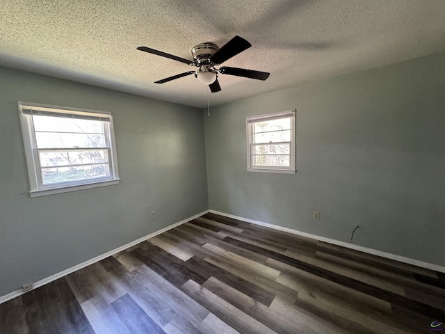 spare room featuring dark wood-style flooring, ceiling fan, a textured ceiling, and baseboards