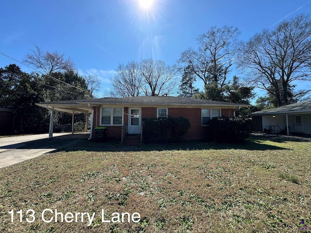 view of front of house with brick siding, an attached carport, concrete driveway, and a front yard