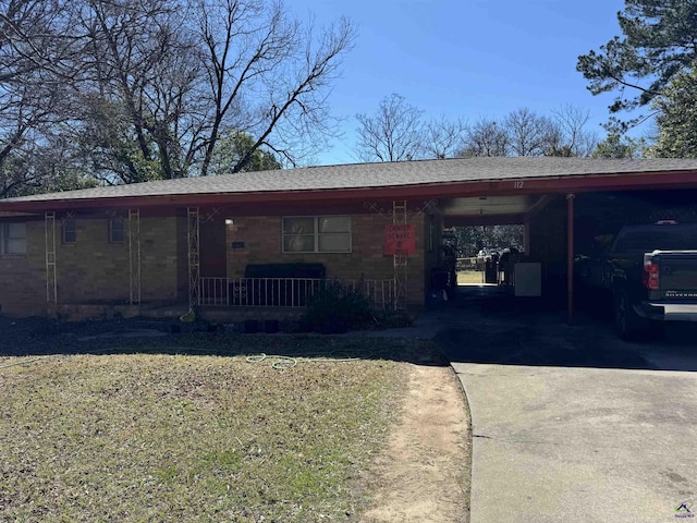 exterior space with a carport, driveway, a porch, and roof with shingles