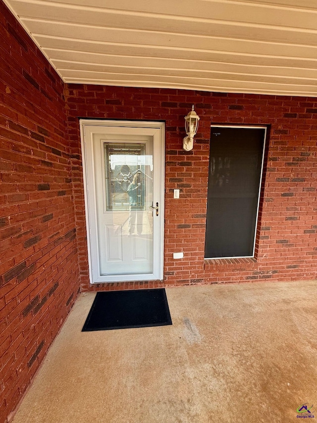 doorway to property with brick siding