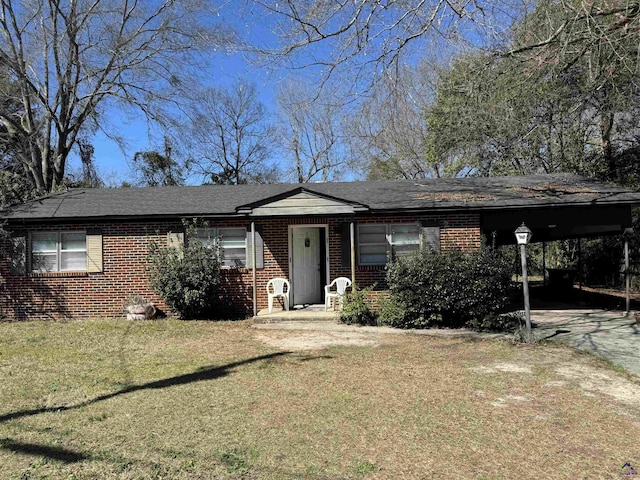 view of front of property featuring a carport, brick siding, driveway, and a front lawn