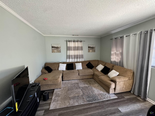 living room with a textured ceiling, ornamental molding, wood finished floors, and visible vents