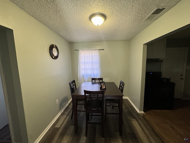 dining room featuring dark wood-style floors, baseboards, and visible vents