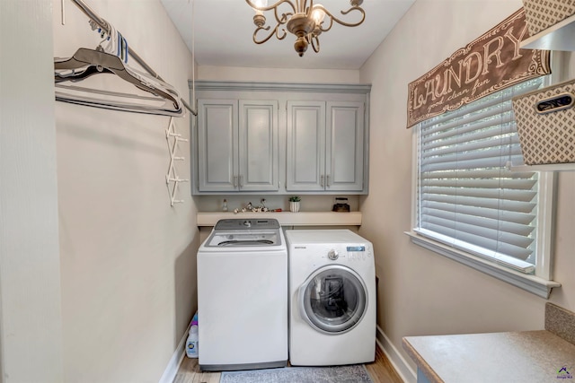 laundry room with a notable chandelier, light wood finished floors, cabinet space, independent washer and dryer, and baseboards