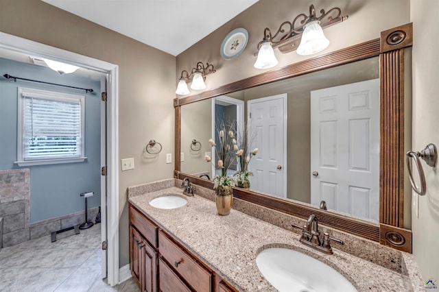 bathroom with tile patterned floors, a sink, baseboards, and double vanity