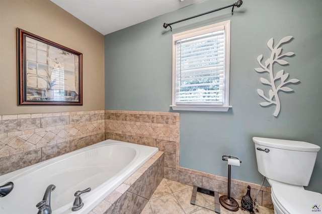 bathroom featuring tile patterned flooring, a garden tub, and toilet