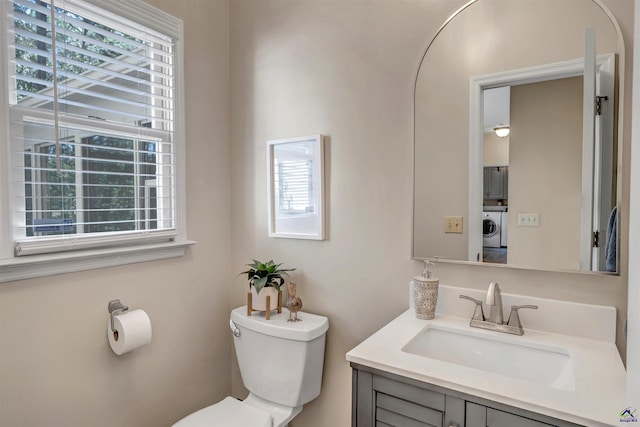 bathroom with washer / clothes dryer, vanity, and toilet