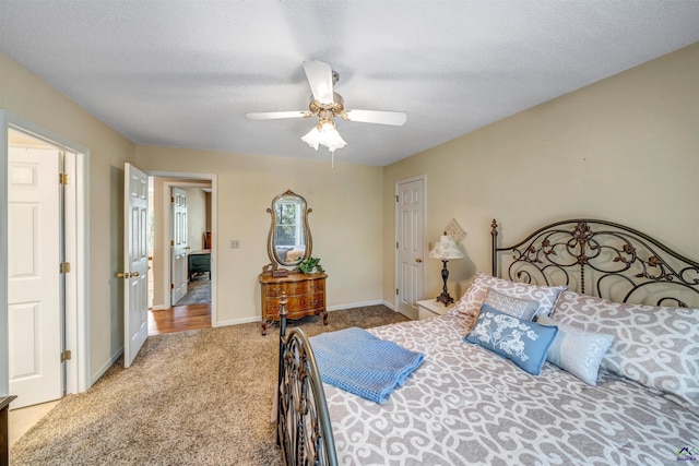 bedroom with a textured ceiling, carpet flooring, a ceiling fan, and baseboards