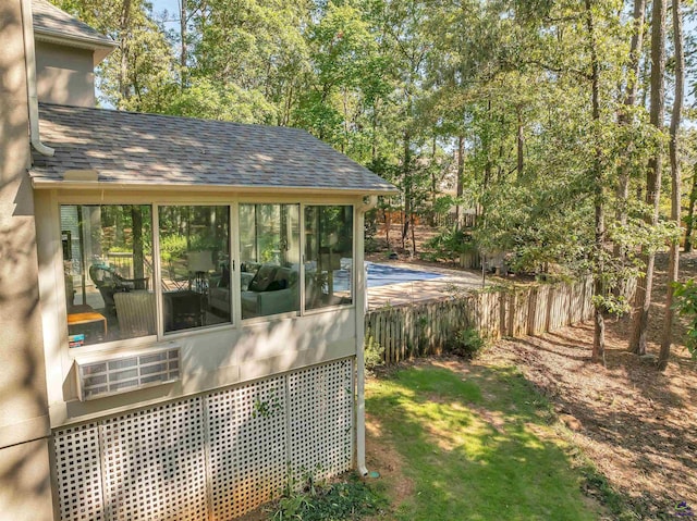 view of yard featuring fence and a sunroom