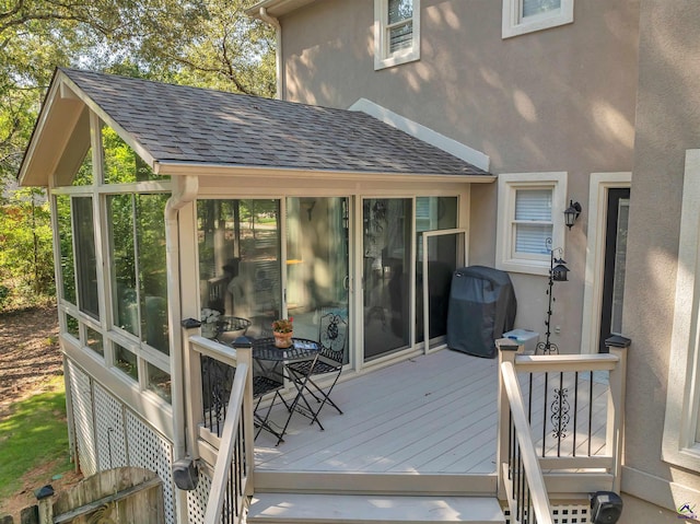 wooden terrace with a sunroom and area for grilling