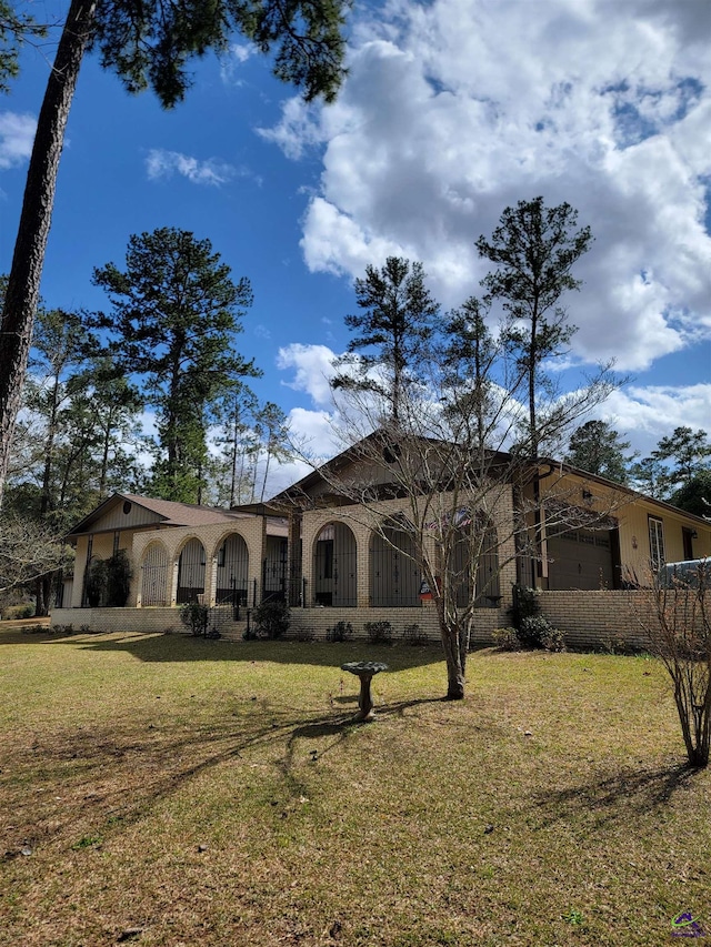 view of front of property featuring a garage and a front lawn