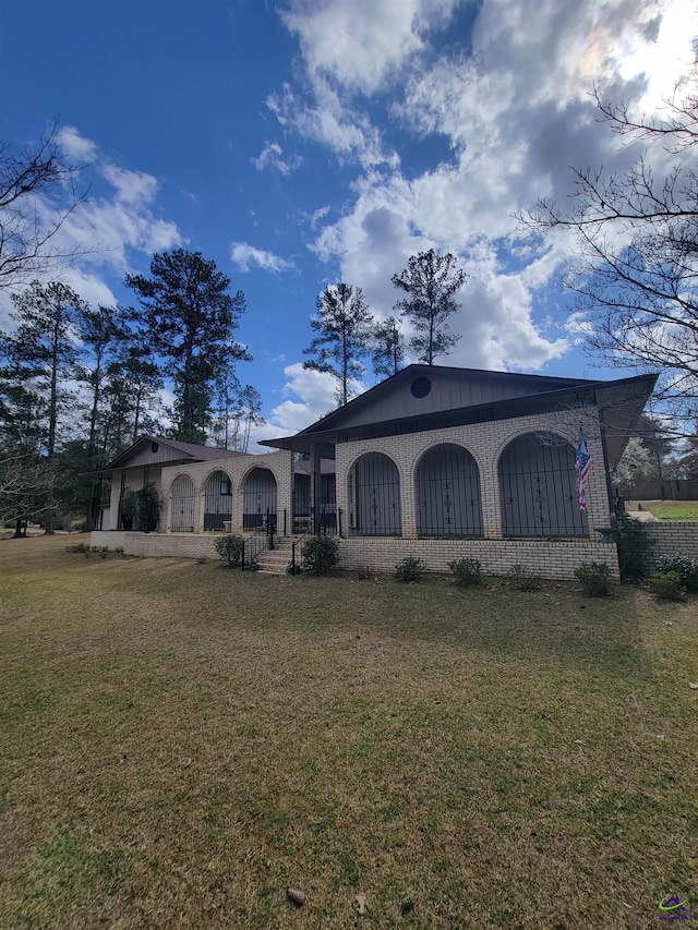 view of front of property featuring brick siding and a front yard
