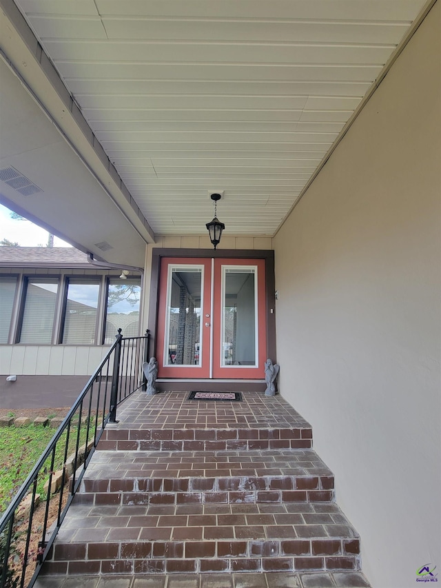 view of exterior entry with french doors and visible vents