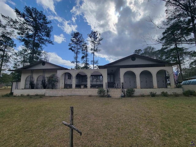 view of front of house featuring brick siding and a front yard