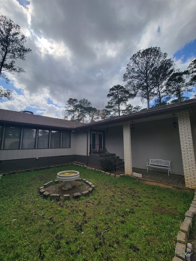 rear view of property with a sunroom and a yard
