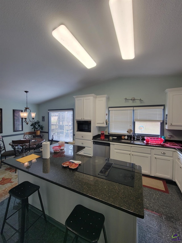 kitchen featuring black appliances, a kitchen bar, white cabinets, and a sink