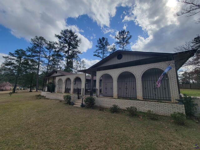 view of front of house featuring brick siding and a front yard
