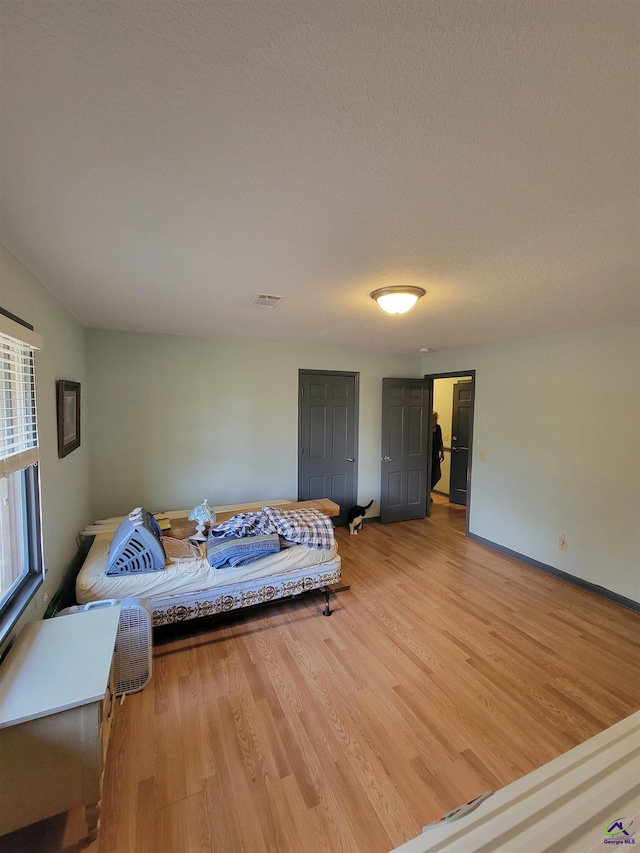 bedroom featuring light wood finished floors and visible vents