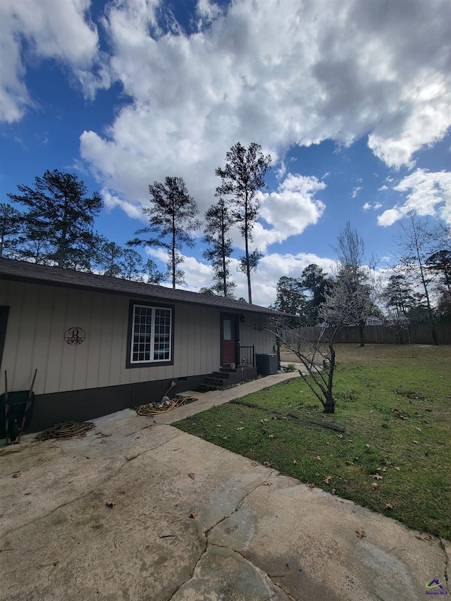 view of side of property with fence and a yard
