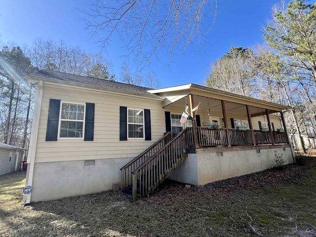 back of property with a porch and crawl space