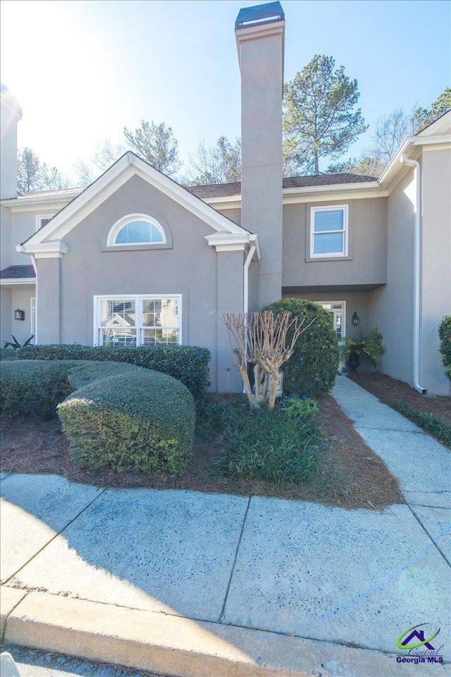 view of front of property featuring a chimney and stucco siding