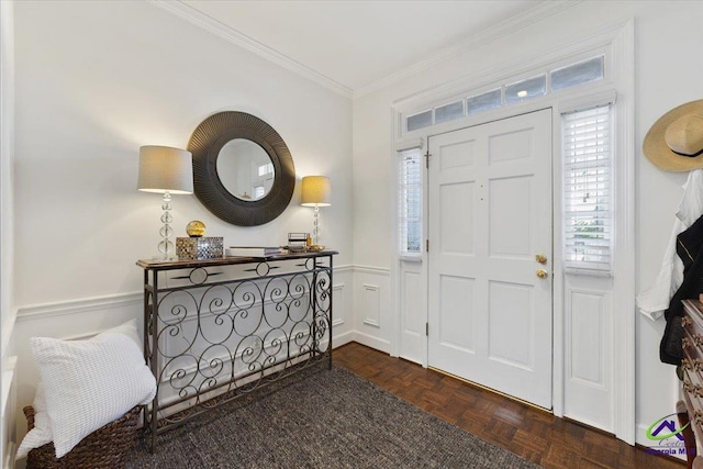 foyer entrance with ornamental molding, wainscoting, and a decorative wall