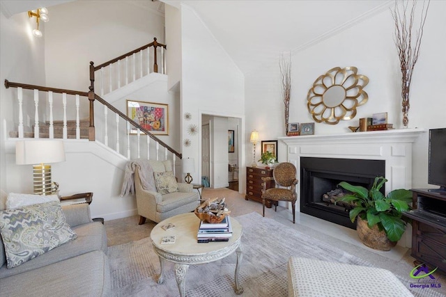 carpeted living room featuring a high ceiling, a fireplace, and stairway