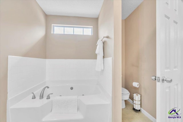 210 Cumberland Woods Ter, Warner Robins, GA 31088 - bathroom featuring a textured ceiling, toilet, baseboards, tile patterned floors, and a whirlpool tub