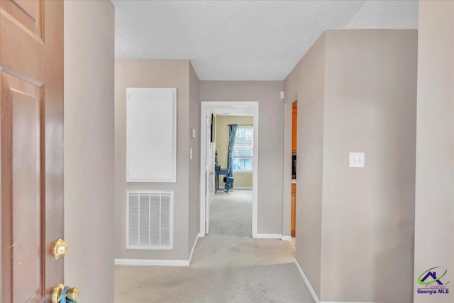 210 Cumberland Woods Ter, Warner Robins, GA 31088 - hall featuring light colored carpet, visible vents, a textured ceiling, and baseboards