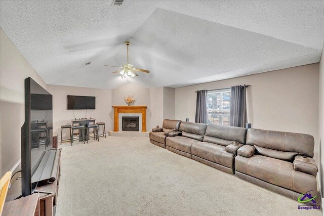 210 Cumberland Woods Ter, Warner Robins, GA 31088 - carpeted living area featuring a ceiling fan, a tile fireplace, vaulted ceiling, and a textured ceiling