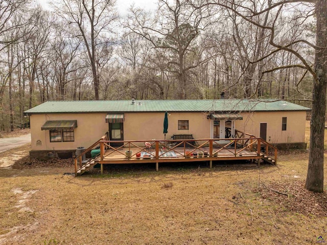 back of property with metal roof and a deck