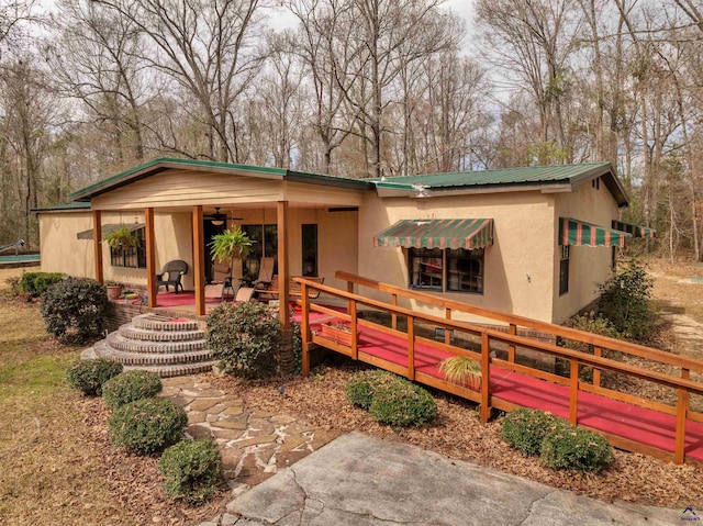 view of front of home featuring metal roof and stucco siding