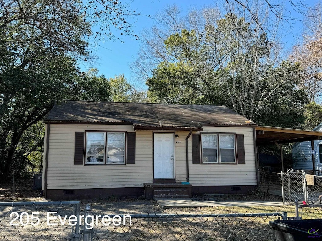 view of front of home with a carport, crawl space, and fence