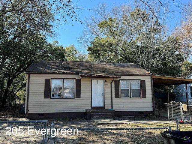 view of front of home with a carport, crawl space, and fence