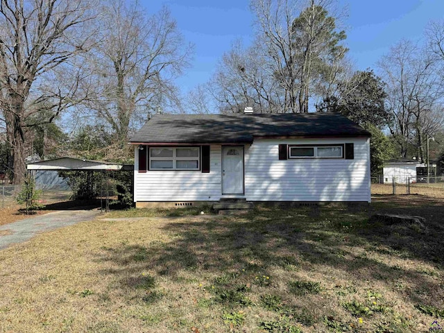 view of front of house with a front yard, entry steps, fence, a carport, and driveway