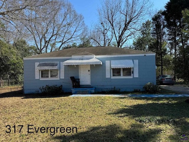 bungalow with crawl space, roof with shingles, and a front lawn