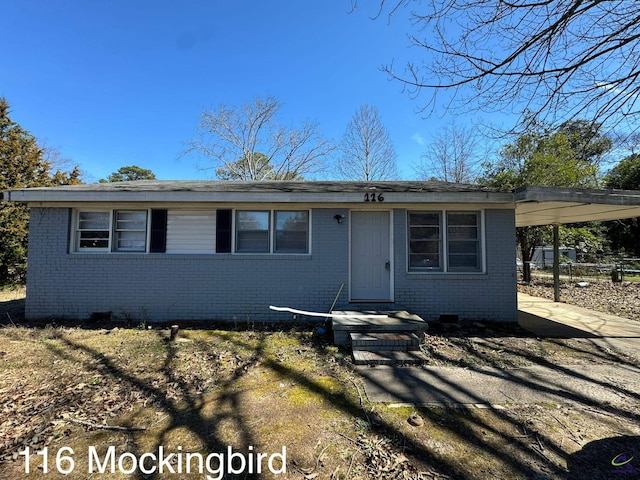 view of front of property with concrete driveway, brick siding, crawl space, and an attached carport