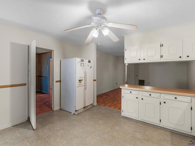 kitchen with white refrigerator with ice dispenser, light floors, light countertops, white cabinets, and ceiling fan