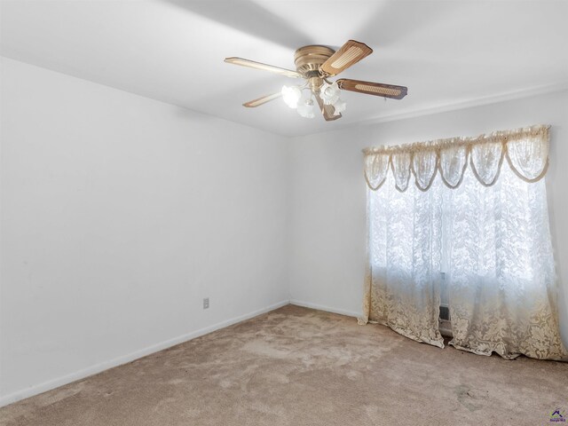 empty room with carpet floors, baseboards, and a ceiling fan